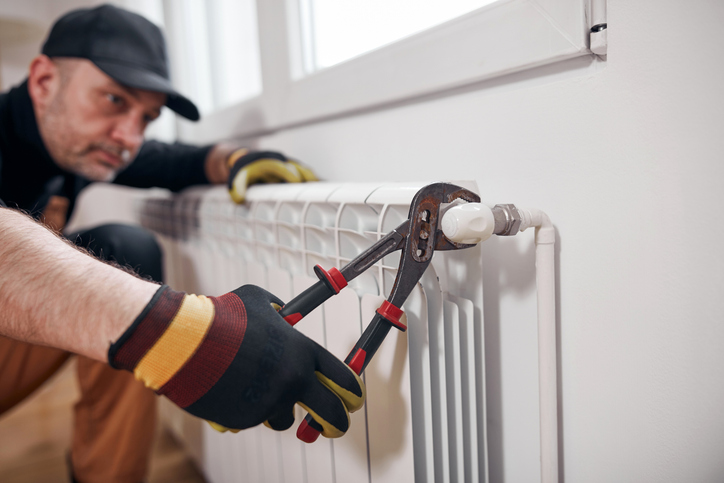Artisan pose radiateur fonte en action